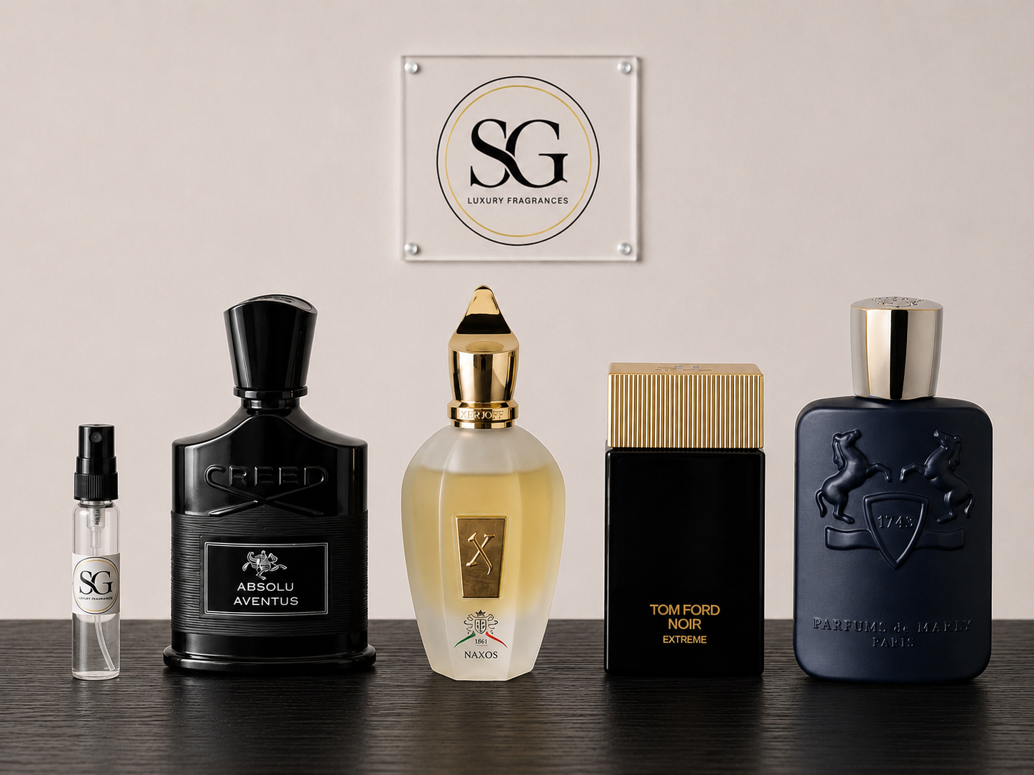 Collection of luxury perfume bottles on a wooden surface with a branded plaque in the background.