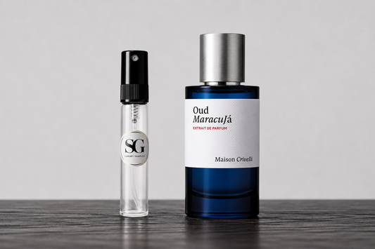 A perfume bottle labeled Maison Orioll 'Oud Maracuja' next to a small clear sample spray vial with a black cap, displayed on a dark wooden surface against a light gray background.