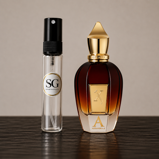 A clear glass perfume sample vial with a black spray top and a circular SG label stands beside a large amber glass perfume bottle with a gold cap and gold front plaque. Both bottles are placed on a dark wooden surface against a warm beige background.
