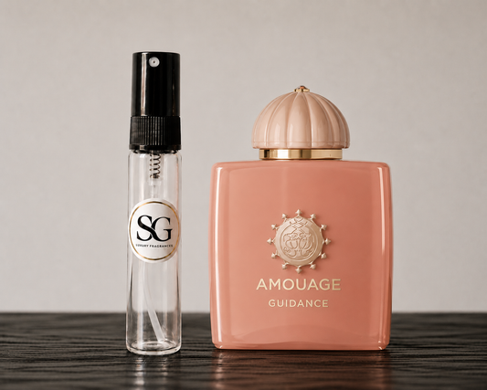 Two perfume bottles, one clear with black cap and gold label, the other pink with gold cap and logo, on a wooden surface.