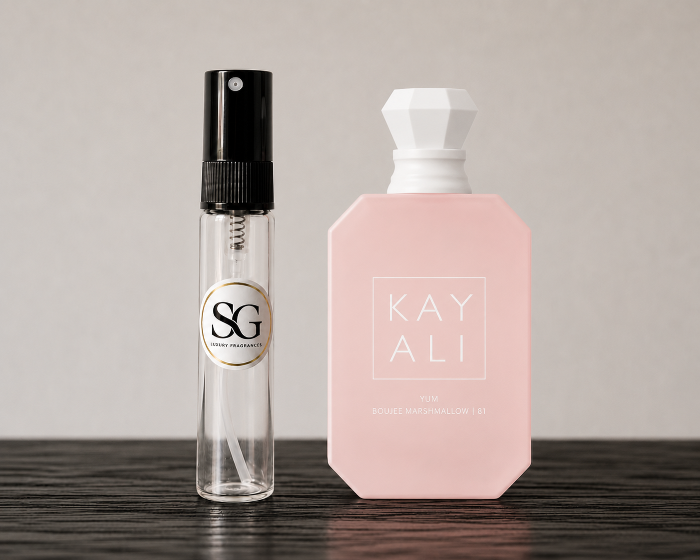 Clear spray bottle with black top and pink bottle with white top on a wooden surface.