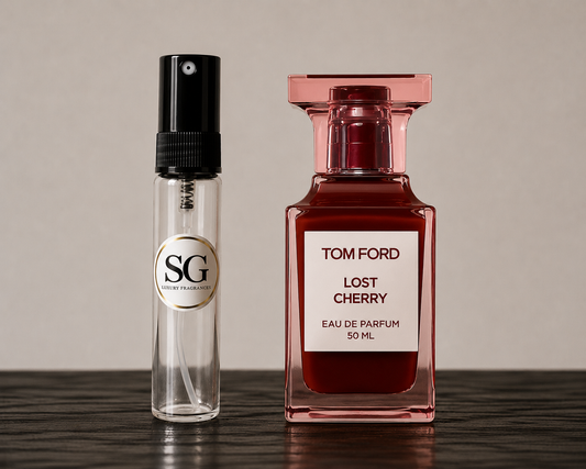 A Tom Ford Lost Cherry Eau de Parfum 50ml bottle next to a clear glass sample spray vial with a black pump and a circular SG (Scent Gallery) logo label, set on a dark wooden surface against a neutral beige background.